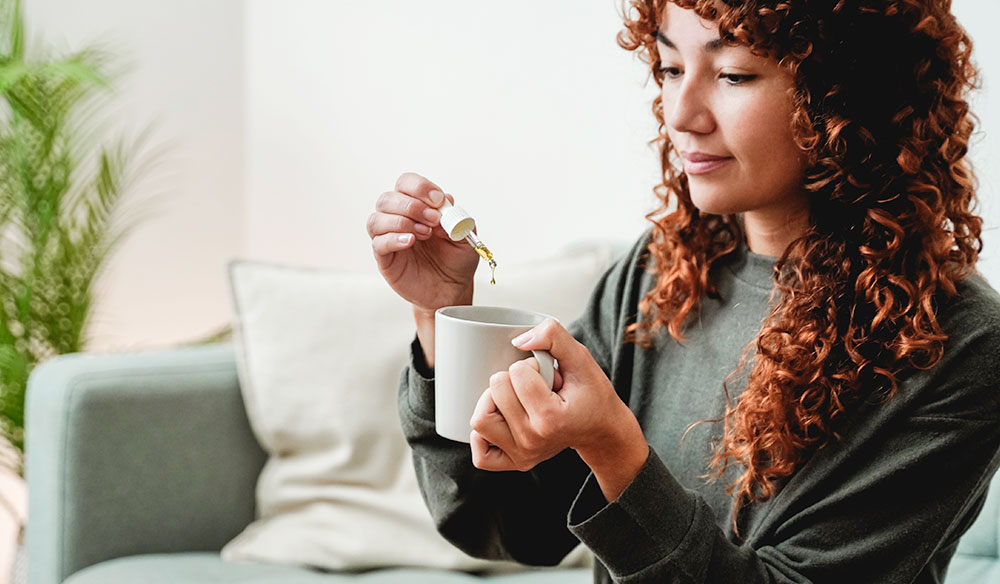 Woman Adding Tincture To Her Drink